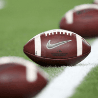 College Footballs Lined Up on the Field