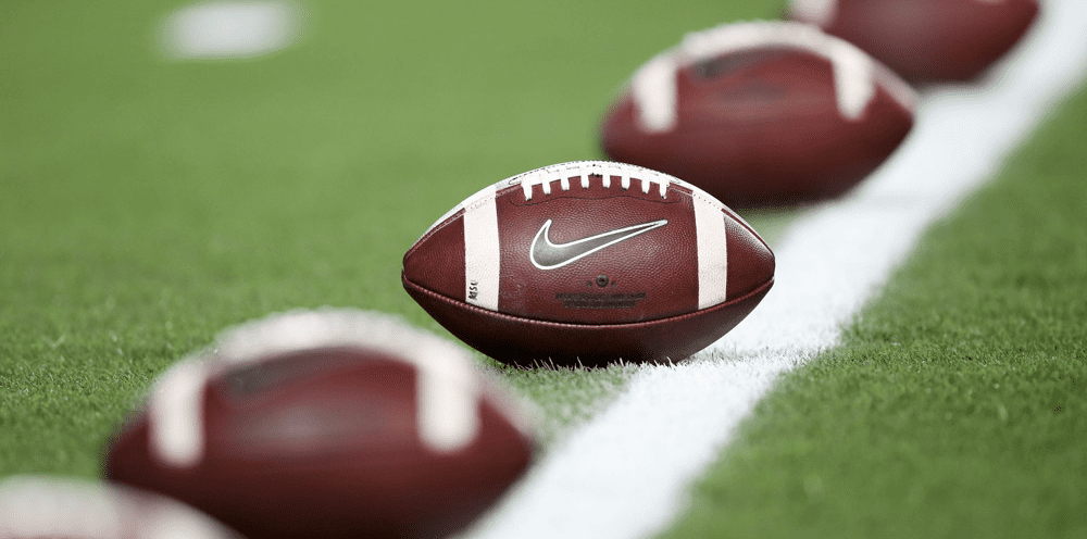 College Footballs Lined Up on the Field