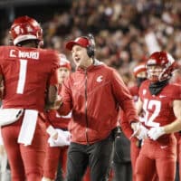 Washington State football team gathers on sideline